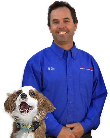 a picture of a smiling technician with a dog next to him